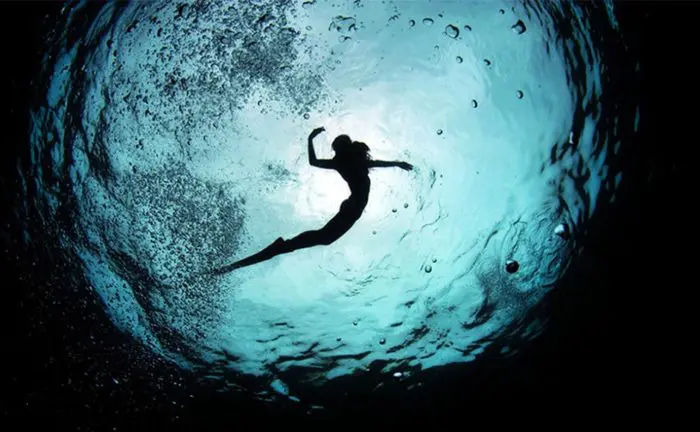 A freediver playing underwater.
