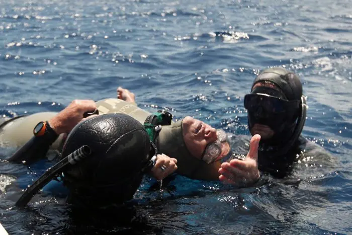 Carolina Schrappe lies unconcious at the surface after suffering a shallow-water blackout and was rescued by safety divers Garo Jack Hachigian and Ren Chapman. She was revived quickly and competing again the next day. Photo © Logan Mock-Bunting