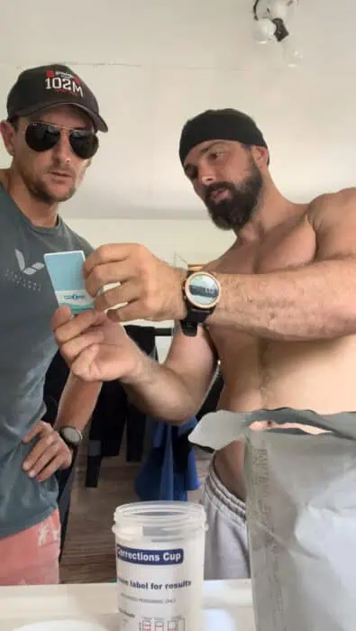 Tory George checking his results during an unofficial doping control administered by William Trubridge on the 3rd competition day of Vertical Blue 2023. Photo provided by Tory George.